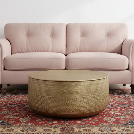 Pink sofa with a woven coffee table on a patterned rug