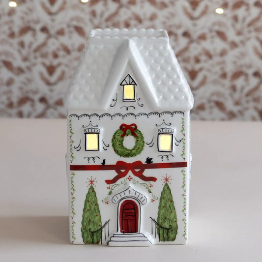 Decorative house-shaped lantern with Christmas design on a neutral background