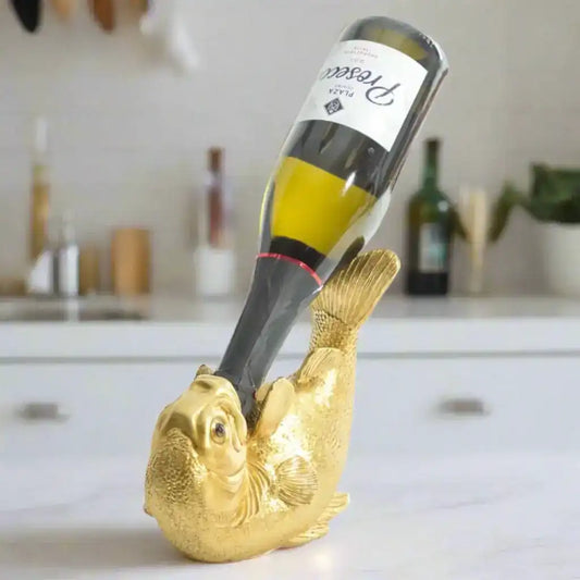 Gold fish-shaped wine bottle holder with a wine bottle inside on a white background