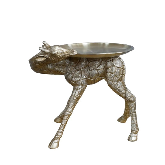 Gold animal-shaped side table against a stone wall background