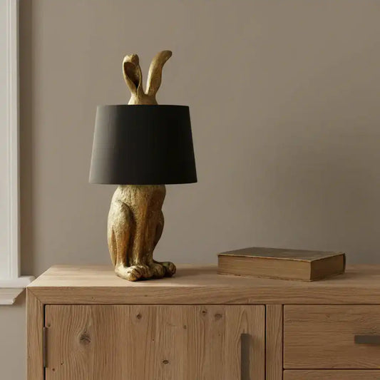 Decorative lamp with rabbit design and black shade on a white background