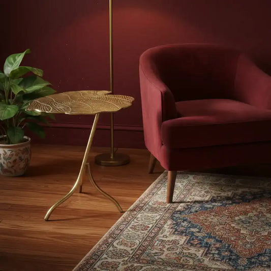 Decorative side table with leaf pattern against a teal wall