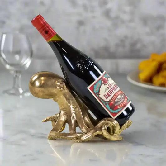 Wine bottle on a decorative brass stand with a white background