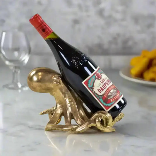 Wine bottle on a decorative brass stand with a white background