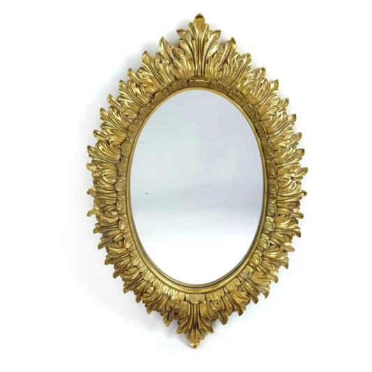 Decorative gold mirror with intricate design on a white background