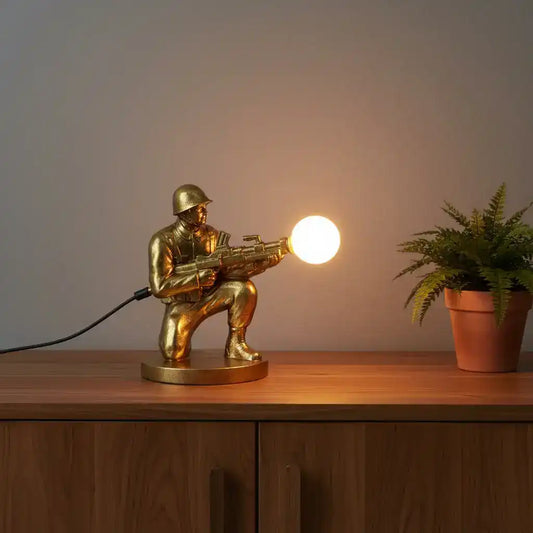 Gold-colored figurine of a soldier with a weapon on a white background