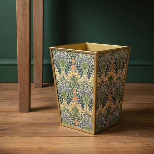 Decorative waste bin with floral pattern on a wooden floor against a green wall