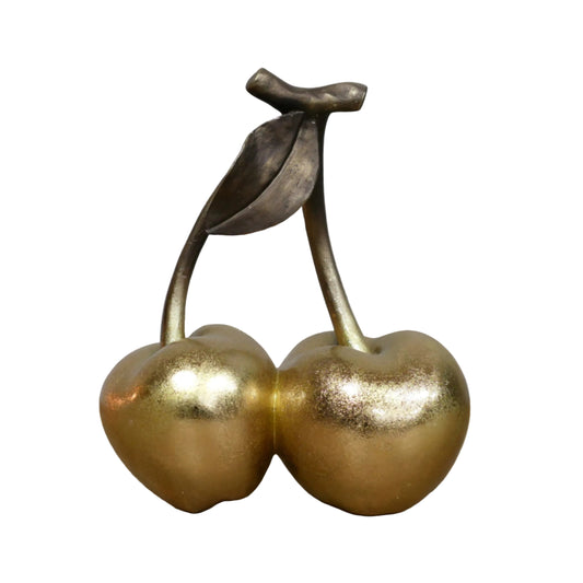 Bronze sculpture of two cherries on a wooden surface with a gray background