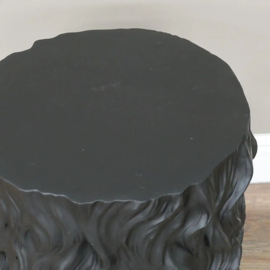 Black textured round table on a plain background