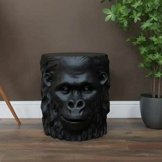 Black gorilla head stool on a wooden floor with a neutral wall background