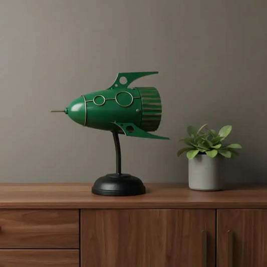 Green rocket-shaped lamp on a wooden surface with a plant in the background