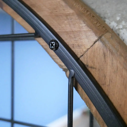 Close-up of a wooden shelf with metal brackets against a blurred background