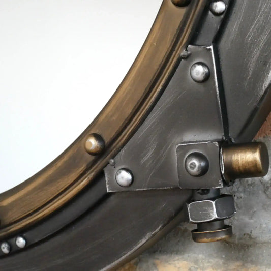 Close-up of a metal object with circular component and bolts on a gray background