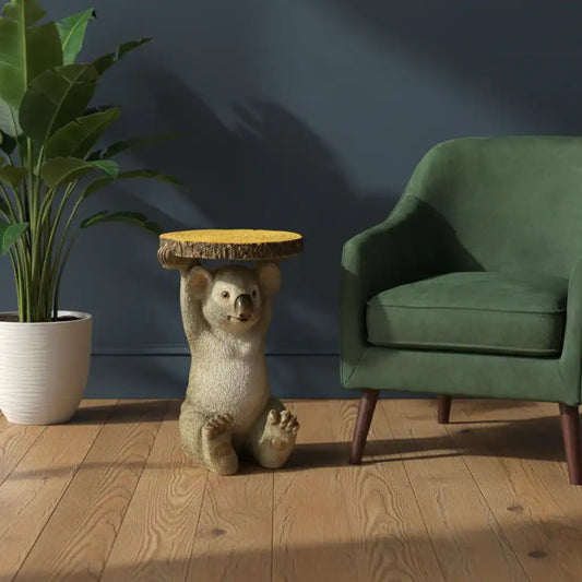 Bear statue holding a wooden table in a room with a green chair and plant.