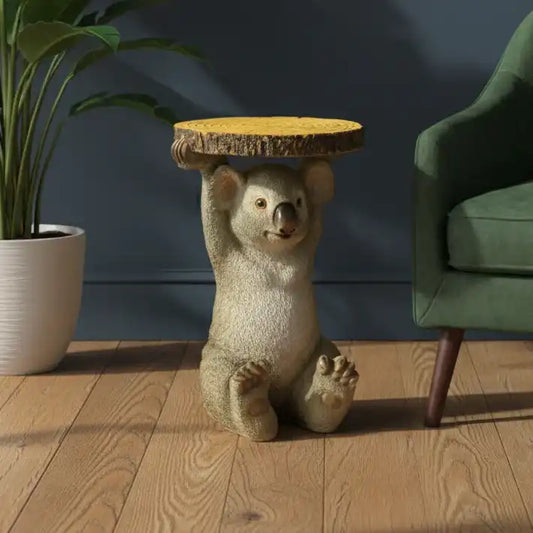 Novelty koala-shaped side table in a room with a plant and green chair.