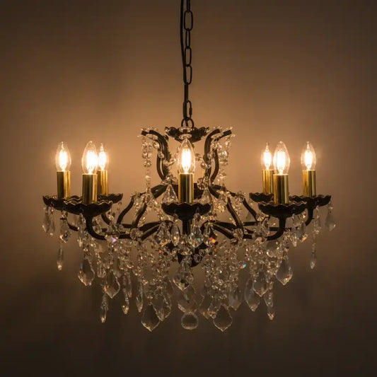 Crystal chandelier with six lit candles against a dark background