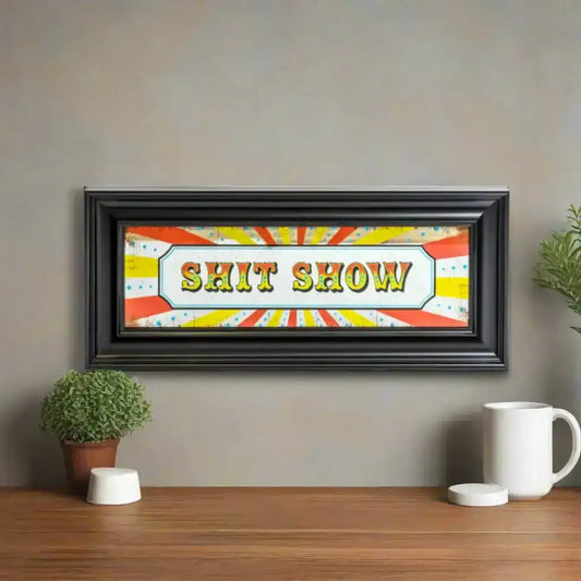 Framed artwork with 'SHIT SHOW' text on a colorful background