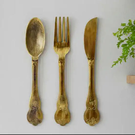 Set of gold-plated spoon, fork, and knife on a white background