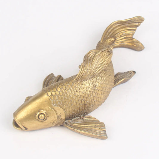 Brass fish-shaped object on a white background
