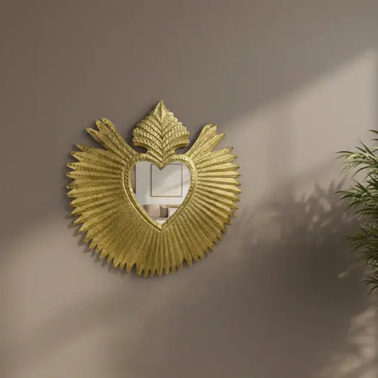 Decorative gold mirror with fan-like design on a beige wall
