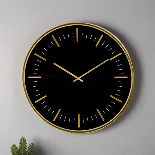 Black wall clock with gold accents on a gray background