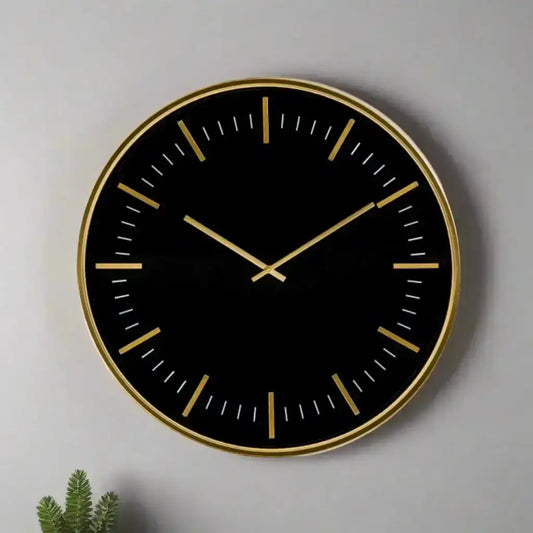 Black wall clock with gold accents on a gray background