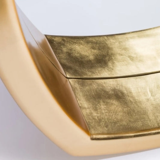 Gold metallic surface with a textured finish on a light gray background