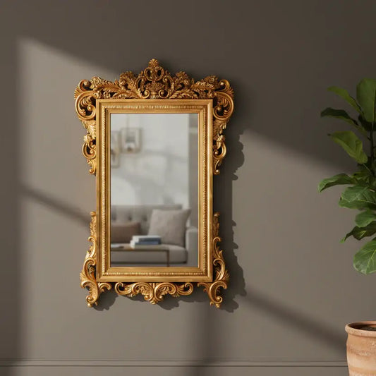 Decorative gold mirror on a wall with a plant to the right