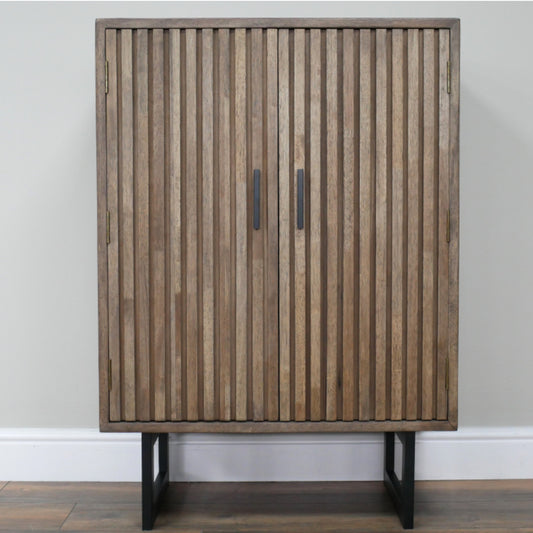 Wooden cabinet with slatted design and black legs against a plain wall.