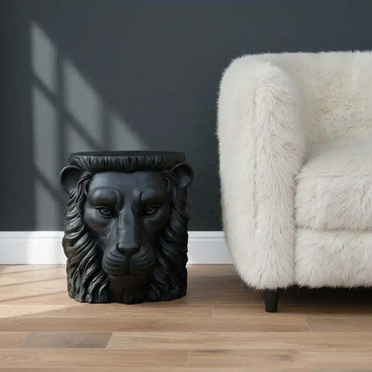 Black lion head sculpture on a wooden surface with a neutral background