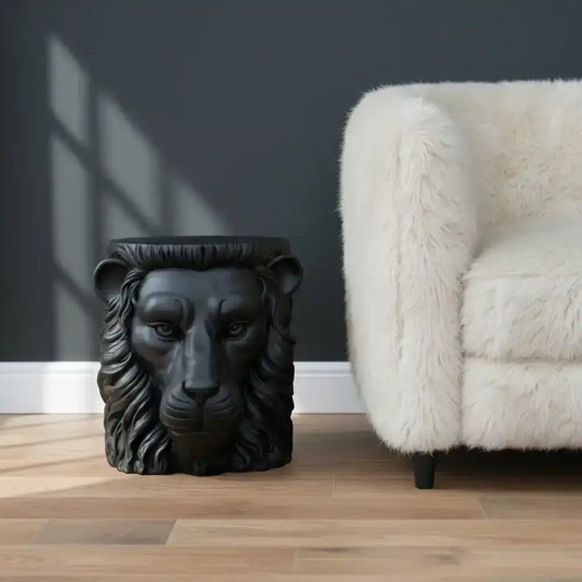 Black lion head sculpture on a wooden surface with a neutral background