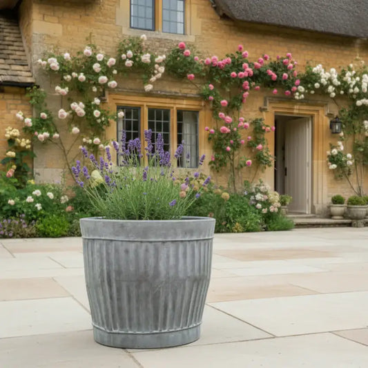 Decorative planter with flowers in front of a stone building
