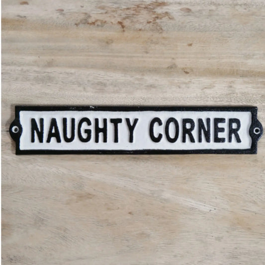 Decorative sign with 'NAUGHTY CORNER' text on a wooden surface