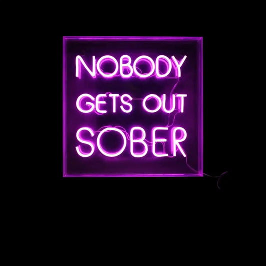 Neon sign with the text 'NOBODY GETS OUT SOBER' on a black background