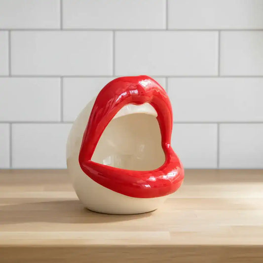 Red and white ceramic lip-shaped object on a white background