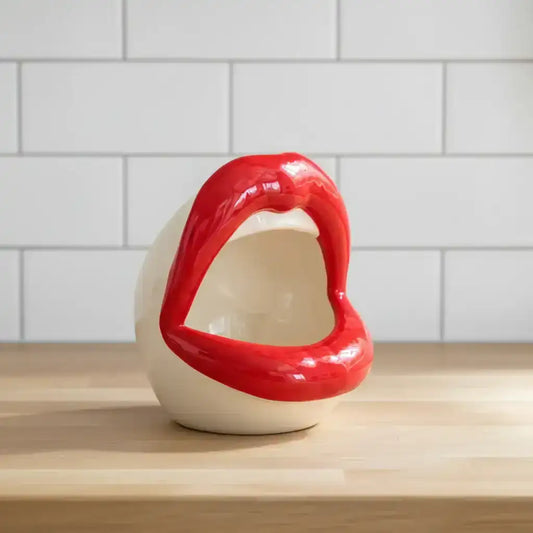 Red and white ceramic lip-shaped object on a white background