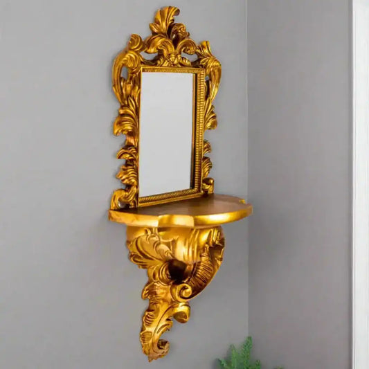 Decorative gold wall mirror with shelf on a white background