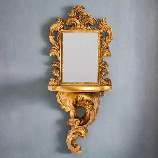 Decorative gold mirror with intricate designs on a white background