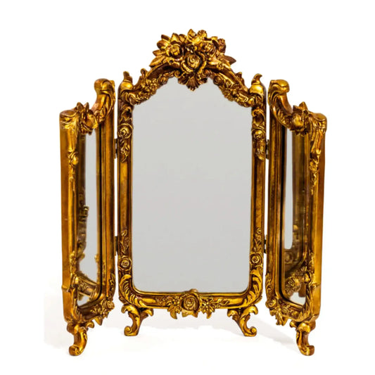 Gold ornate tri-fold mirror on a white background