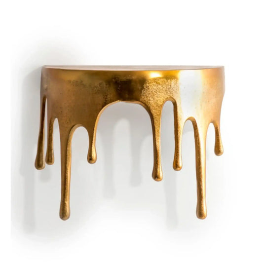 Decorative wall shelf with gold metallic finish and dripping effect on a white background