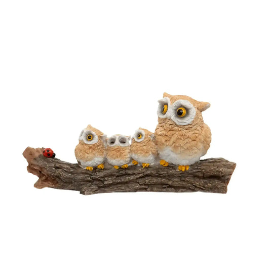 Owl family figurine on a branch with a white background