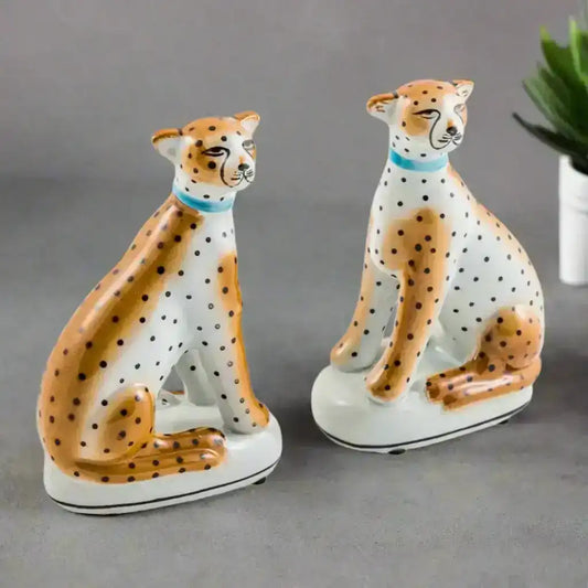Two ceramic cheetah figurines on a white background