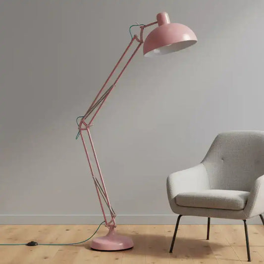 Pink floor lamp and gray chair against a plain wall.