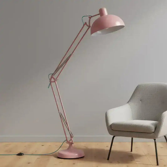 Pink floor lamp and gray chair against a plain wall.