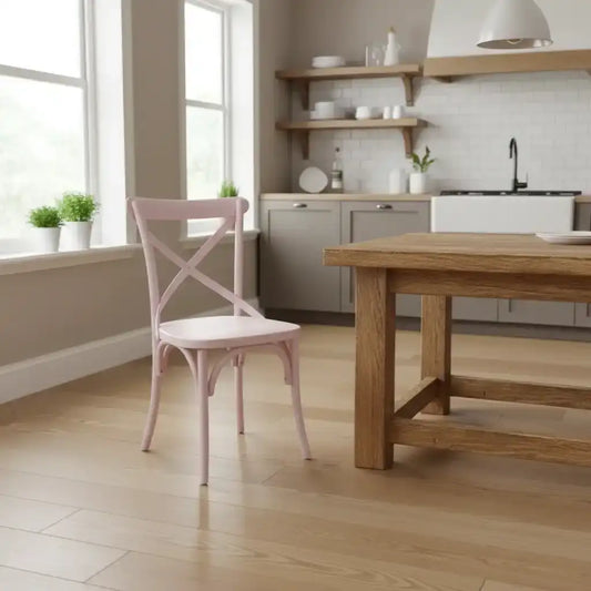 Modern kitchen with wooden table and pink chair, light wood flooring and neutral walls.
