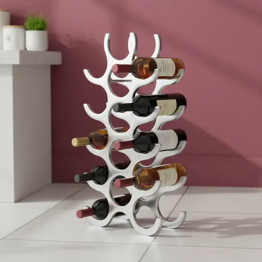 White wine rack holding multiple bottles against a pink wall.