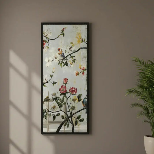 Framed floral artwork with birds on a wall next to a plant