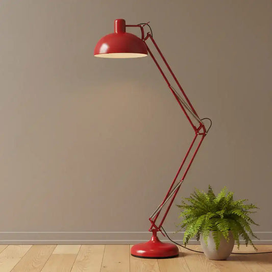 Red floor lamp with a plant on a wooden floor against a beige wall