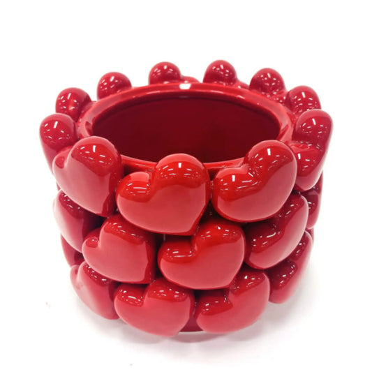Red ceramic planter with heart designs on a white background