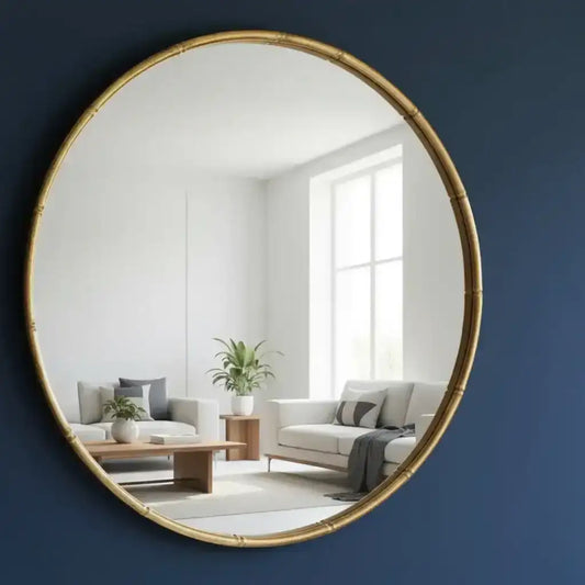 Round gold-framed mirror on a wall with a blurred indoor background